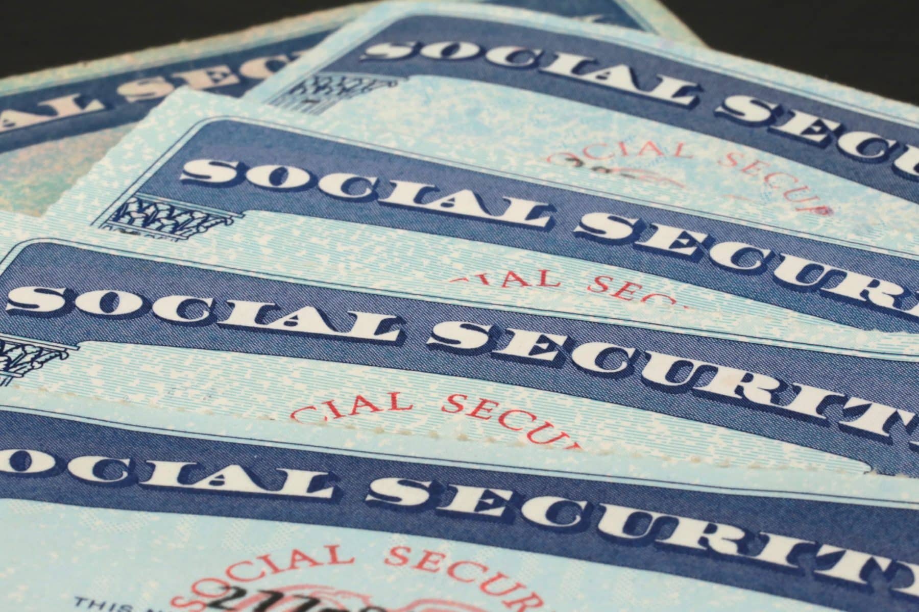 Multiple social security cards are positioned in a row.