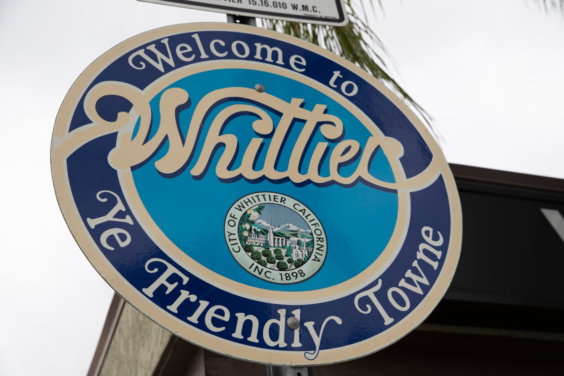 “Welcome to Whittier” sign featuring the city seal of Whittier, California, with the words “Ye Friendly Towne” displayed below.
