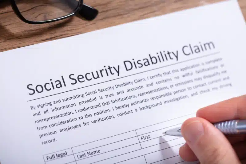 person filling out a Social Security Disability claim form
