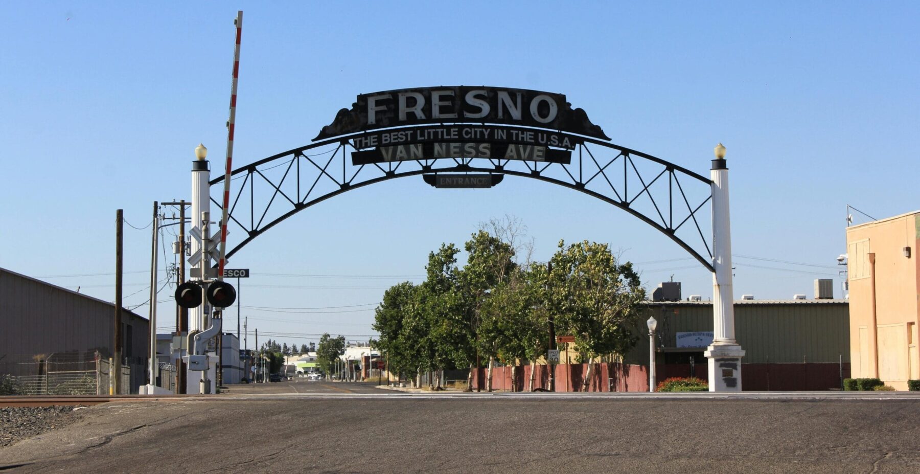 Historic Fresno arch reading “Fresno – The Best Little City in the U.S.A.” spanning Van Ness Avenue under a clear blue sky.